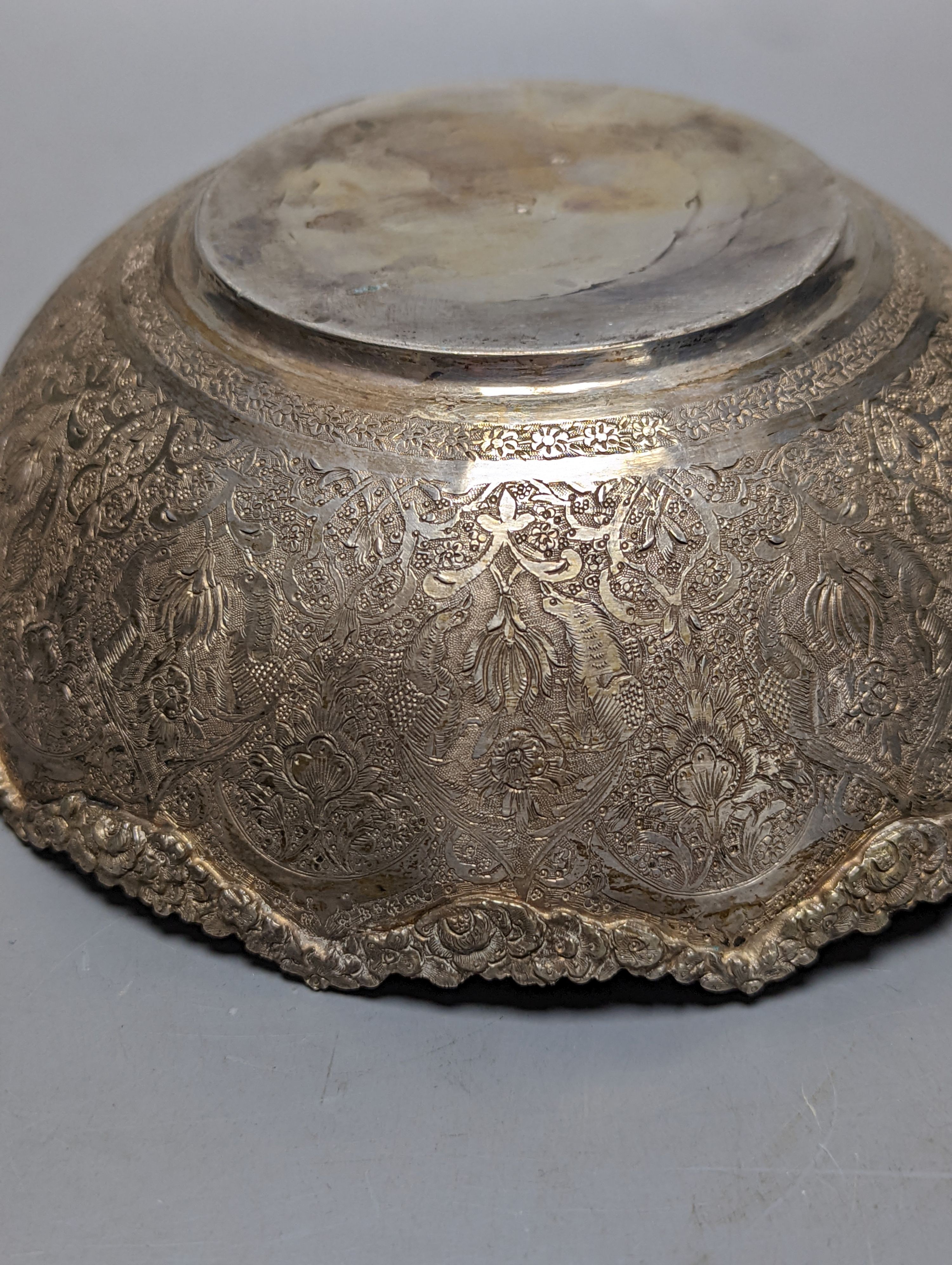 A Persian engraved white metal bowl, diameter 17.9cm and a similar stand or plate, 22cm, 20oz.